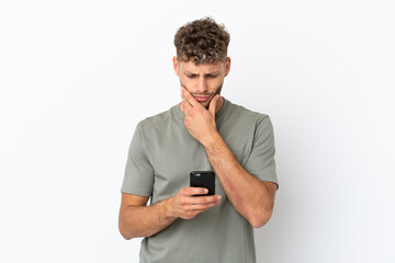 Young caucasian handsome man isolated on white background thinking and sending a message