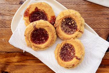 Overhead view of four homemade butter cookies with jam. Homemade and natural food concept.