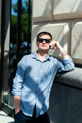 Caucasian man forty years old businessman near the building talking on the phone