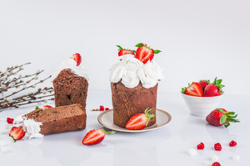 Easter cake made of chocolate dough, decorated with meringues and strawberries. Easter decor on white background 