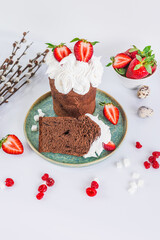 Easter cake made of chocolate dough, decorated with meringues and strawberries. Easter decor on white background 