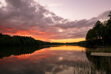 Fototapeta na wymiar Spectacular and colorful sunset over lake
