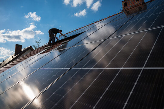 Photovoltaic panels on the roof and intaller in the background