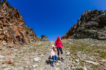 Fototapeta premium Happy hiker woman and girl at mountains lake