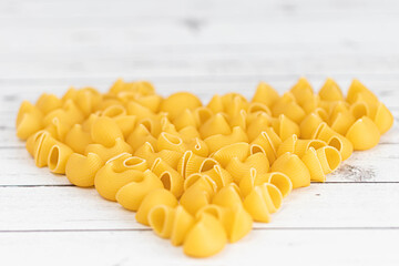 Food.Pasta raw closeup background. Delicious dry uncooked ingredient for traditional Italian cuisine dish. Textured variety shapes. Top view. heart shape