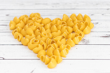 Food.Pasta raw closeup background. Delicious dry uncooked ingredient for traditional Italian cuisine dish. Textured variety shapes. Top view. heart shape