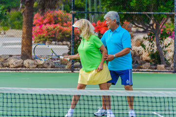 Senior couple playing tennis on sunny day.