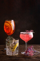 different beautiful cocktails in warm colors on a dark background.