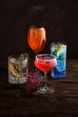 different beautiful cocktails in warm colors on a dark background.