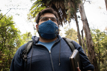 Portrait of a young handsome Hispanic student returning to school after pandemic
