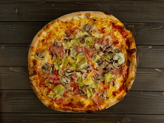 Pizza capricciosa. Pizza with tomato, mozzarella, artichokes, mushrooms and ham. Italian food.