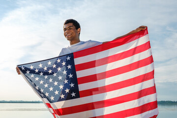 African American man looking at camera and proudly holding American flag