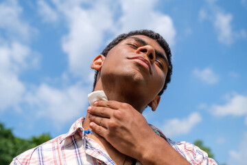 Wet wipe closeup in hands of young Brazilian man outdoors in park