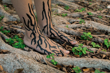 Feet with painted roots surrounded by roots in a park