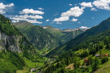 Fototapeta na wymiar Summer valley with Grossarler Ache small river and blue cloudy sky