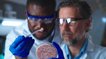Multiracial scientists examining cell meat in Petri dish