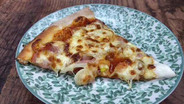 Part de pizza oignon fromage sur une assiette