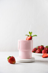 Strawberry lassi, smoothie or milkshake on a white background. Vertical format. Healthy dairy...