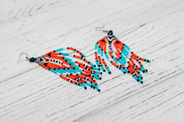 Ethnic decoration of an earring, visonane with a bead. Hand weaving beading, geometric pattern.