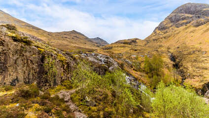 Fototapeta na wymiar A view towards mountain streams at Glencoe, Scotland on a summers day