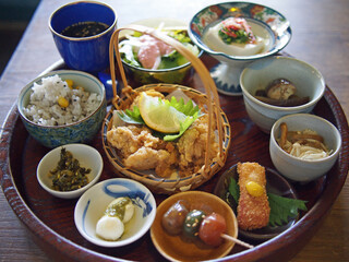 お盆に数々のおばんざいが盛られた健康的な和食