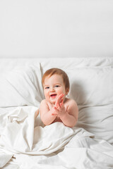 Redhead Toddler on bed smiles. Infant development concept, toddler restful sleep, teething, colic.