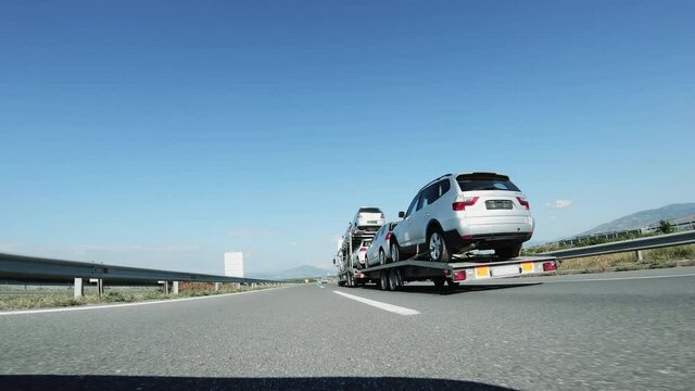 A large truck / car transporter delivers used cars driving on highway