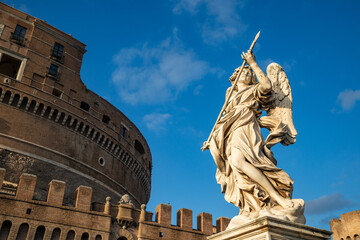 Fototapeta na wymiar Angel with the spear of the Bernini school with the Castel Sant'Angelo, Vatican, from the Ponte degli Angeli over the Tiber, with a clear blue sky after a thunderstorm, Vatican, Rome, Italy.