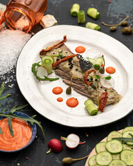 Slices of tenderloin with cucumber roll and radish. Beautiful food serving. Vertical format. Soft focus.