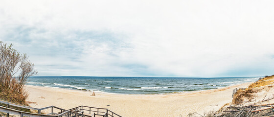 Frame of a wooden hut on a sandy beach on the Baltic Sea with waves on the Curonian Spit