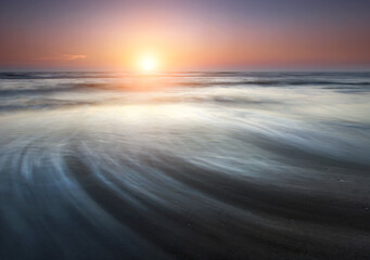 Fototapeta na wymiar Beautiful sunrise over the sea. Motion blur waves. Fresh new start concept.