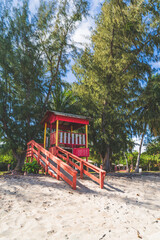 Fototapeta na wymiar Red Lifeguard hut along shore of Seven Sea beach in tropical Fajardo Puerto Rico