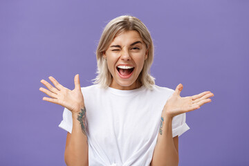 Waist-up shot of playful energized sociable attractive woman with blond hair, tanned skin and...