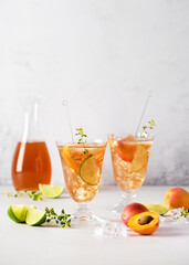Fresh apricot cocktail with ice, lime and lemon thyme in glass. Refreshing, homemade non-alcoholic cocktails in summer. Selective focus. Copy space.