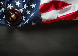 National flag of the United States of America and a wooden judge's gavel. Dark gray background. High angle view. Minimalism. Empty space for your insert. - obrazy, fototapety, plakaty