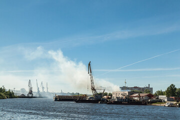 Fototapeta na wymiar Small river port with industrial cranes