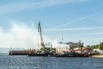 Fototapeta na wymiar Small river port with industrial cranes