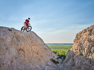 Senior man is riding a fat mountain bike in badlands of Pawnee National Grassland in northern...