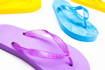 multi-colored rubber beach flip flops on a white background