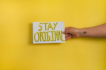 A closeup shot of a woman holding a paper with the word 