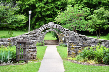 Stone walls and archways in a garden surrounded by verdant plants