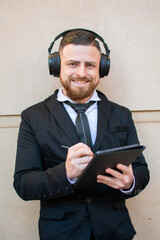 hombre latino caucásico sonriente con barbijo vestido formalmente tomando apuntes en su Tablet en...