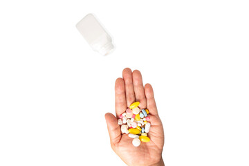 Colorful pills and medicines in women hand and white bottle.