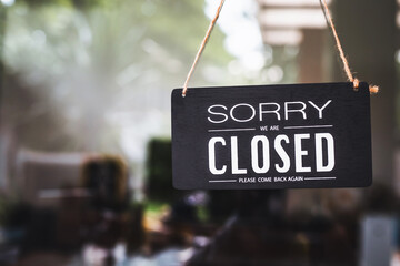 sorry closed sign on shop door. Text on cafe front or restaurant hang on door at entrance. vintage tone style.