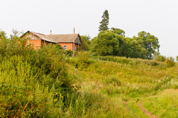 Brick house on the background of a green landscape.
