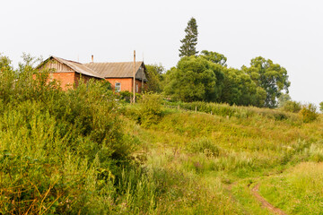 Fototapeta na wymiar Brick house on the background of a green landscape.