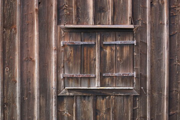 geschlossene Fensterläden an einer alten Scheune, alles ist aus Holz