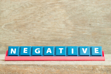Tile alphabet letter with word negative in red color rack on wood background