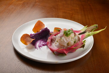 cold pink dragon fruit salad with root paste appetiser on wood table fine dining western menu