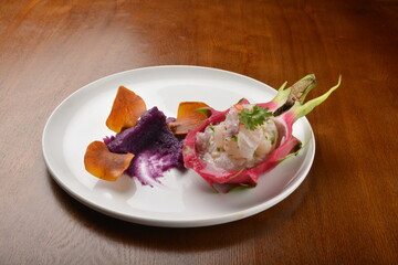 cold pink dragon fruit salad with root paste appetiser on wood table fine dining western menu
